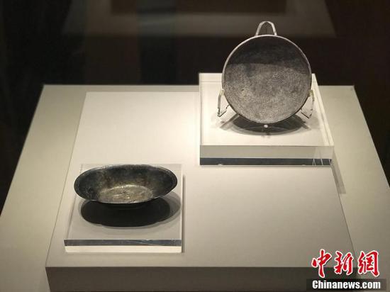 唐代双鱼纹海棠花形鎏金银盏（左）、唐代绶带纹银碗（右）。